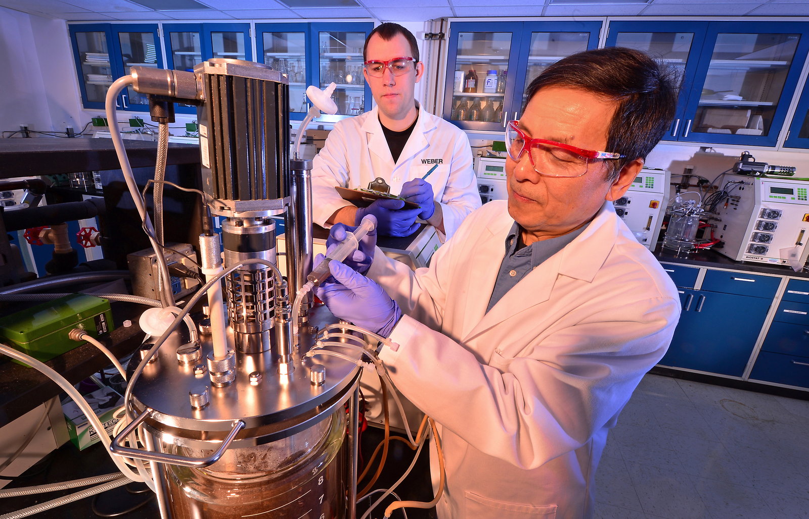 USDA researchers loading yeast into a bioreactor used to ferment ethanol from corncob waste.